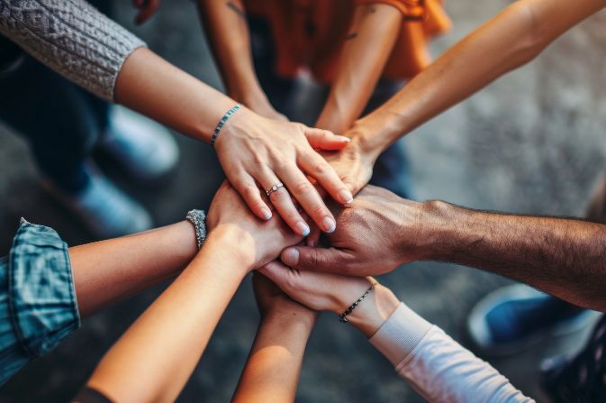 Eight hands joining together to represent team work
