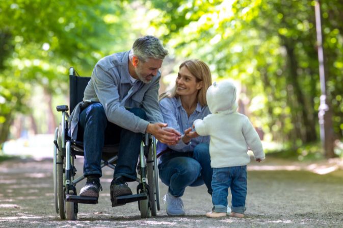 Man in a wheelchair with woman and child