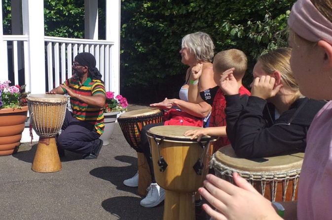 Children and carers playing drums