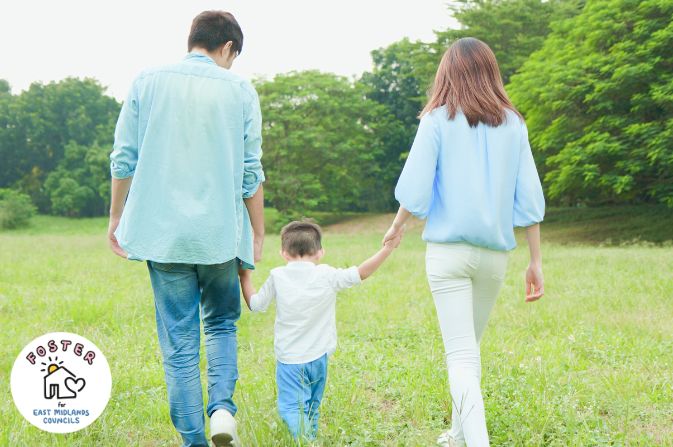 Male and female with a child walking in a park